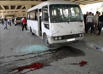 باص للشرطة ودماء على الأرض بعد التفجير الانتحاري في حي الميدان في دمشق أمس (أ ب) 
