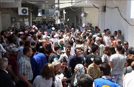 سوريون ينتظرون للإدلاء بأصواتهم في الانتخابات التشريعية في مركز اقتراع في دمشق أمس (أ ف ب) 