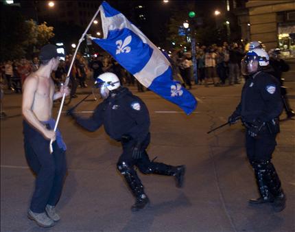 شرطي يتعرض لطالب متظاهر في مونتريال مساء أمس الأول (رويترز) 