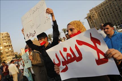 مصريون يرفعون لافتات ضد «الفلول» في ميدان التحرير في القاهرة أمس (أ ف ب) 