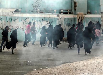 متظاهرون يهربون من قنابل الغاز التي ألقتها شرطة مكافحة الشغب في دراز في البحرين أمس. (أ ب) 