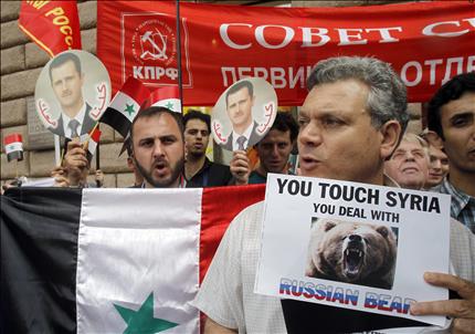 متظاهرون يحملون صوراً للأسد وعلم الحزب الشيوعي يتظاهرون أمام السفارة الأميركية في موسكو أمس (أ ب) 