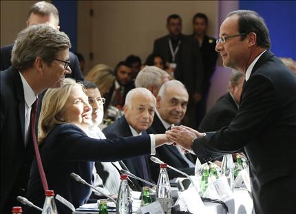 هولاند يصافح كلينتون ويبدو الأمين العام للجامعة العربية نبيل العربي ووزير خارجية ألمانيا غيدو فسترفيله في باريس أمس 
