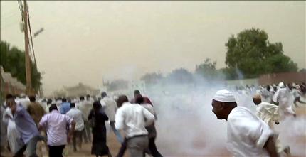 متظاهرون يهربون من قنابل الغاز المسيل للدموع خارج مسجد ودنوباوي في ام درمان في الخرطوم امس (أ ف ب) 