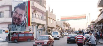صور اوجلان وأعلام»الكردستاني» في مدينة العامودي في شمال سوريا 