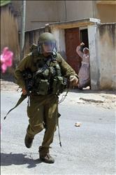 فلسطينية ترشق جندياً من الاحتلال بالحجر قرب نابلس في الضفة الغربية أمس (أ ب أ) 
