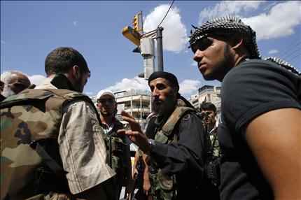 قائد للمسلحين يعطي تعليماته لعناصره في حي سيف الدولة في حلب أمس (رويترز) 