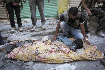مسلح سوري ينتحب فوق جثة مسلح آخر قتل بقذيفة دبابة في حلب أمس (أ ب) 
