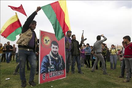 مسلحون اكراد يحتفلون بطرد مسلحين تابعين لتنظيم "القاعدة" من قرية قرب بلدة رأس العين الحدودية مع تركيا امس (رويترز) 