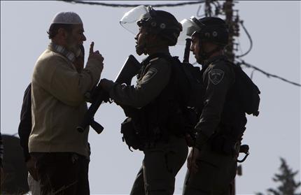 فلسطيني يواجه جنديين إسرائيليين خلال هدم منشأتين ومنزل في حي سلوان في القدس المحتلة أمس 