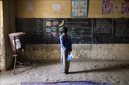 طفل مالي يقف أمام اللوح في مدرسته في تمبكتو أمس. وافتتحت المدارس أبوابها للمرة الأولى أمس بعد توقف استمر عشرة أشهر (أ ف ب) 