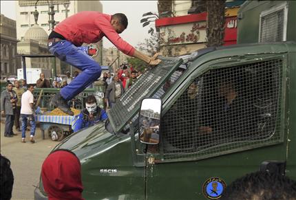 متظاهر معارض لمرسي يواجه آلية للشرطة في القاهرة أمس (رويترز) 