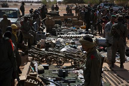 جنود ماليون يعرضون في القاعدة الفرنسية في غاو، أمس، أسلحة غنموها خلال المعارك (أ ب) 