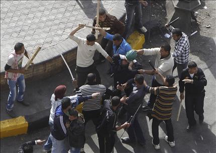 عناصر من الشرطة المصرية بلباس مدني يضربون بالهراوات متظاهرا ضد مرسي في ميدان التحرير في القاهرة امس (رويترز) 