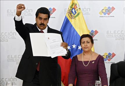 مادورو يرفع وثيقة الاعتراف بفوزه في الانتخابات الرئاسية في كراكاس أمس الأول (أ ف ب) 