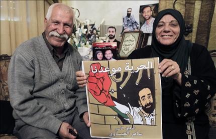 والدا سامر العيساوي يحملان صورته في منزلهما في العيسوية في القدس المحتلة أمس (ا ب ا) 