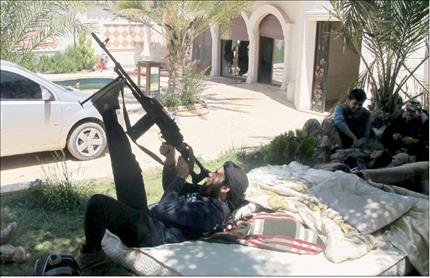 مسلحون داخل منزل في بلدة خان العسل في ريف حلب امس الاول (رويترز) 