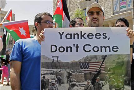 اردني يحمل لافتة كتب عليها «يانكيز لا تأتوا» خلال تظاهرة في عمان امس رفضا لتعزيز واشنطن وجودها العسكري في الاردن (ا ف ب) 