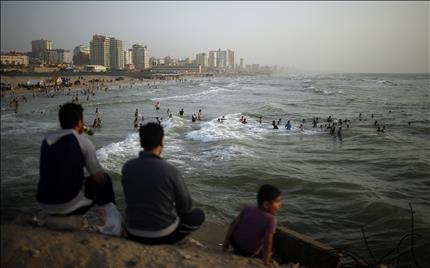 فلسطينيون على شاطئ مدينة غزة أمس (رويترز) 