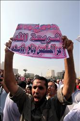 سلفي مصري يحمل لافتة كتب عليها «شريعة الله عز المسلمين وتاج رؤوسهم» خلال تظاهرة في القاهرة أمس (أ ب أ) 