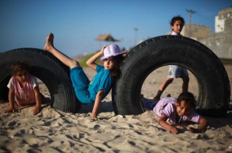 أطفال غزة يلهون على شاطئها بعد انتهاء العام الدراسي (محمد عبد ــ أ ف ب) 