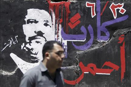 مصري يسير امام جدارية تحمل شعارات مناهضة لمرسي في القاهرة امس (رويترز) 