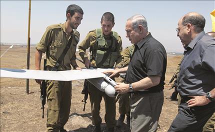 نتنياهو وخلفه يعلون يطلعان على طائرة من دون طيار خلال تدريبات لقوات الاحتلال في الجولان المحتل امس (ا ب ا) 