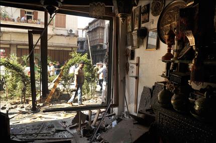 شرطي سوري يتفقد موقع التفجير الانتحاري في باب توما في دمشق القديمة امس (ا ب ا) 