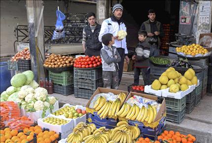 سوري يشتري الخضار من احد المحال في دمشق (رويترز) 
