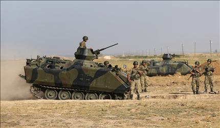 قوات تركية تنتشر قرب الحدود السورية أمس (رويترز) 