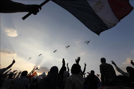 طوافات تابعة للجيش المصري تحلق فوق المتظاهرين في ميدان التحرير في القاهرة امس (رويترز) 