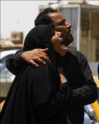 عراقيان يبكيان خلال المشاركة في تشييع ضحايا أعمال العنف في النجف أمس (رويترز) 