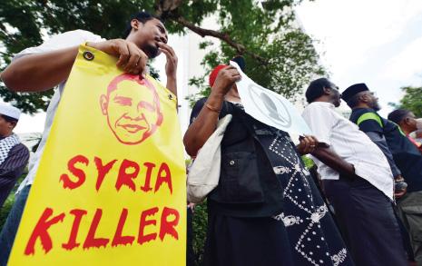 خلال تظاهرة رافضة للعدوان الغربي على سوريا أمام السفارة الأميركية في ماليزيا أمس (أ ف ب) 