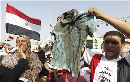 شاب مصري يحمل قميصا ملطخة بالدماء في رابعة العدوية بعد الاشتباكات امام مقر الحرس الجمهوري في مدينة نصر امس (رويترز) 