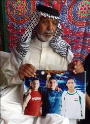 ناظم الجبوري يرفع صورة لأولاده الذين قضى اثنان منهم بتفجير سيارة يوم السبت الماضي تزامناً مع الذكرى السادسة لمقتل أخوهما في نفس المكان، في بغداد أمس (أ ف ب) 