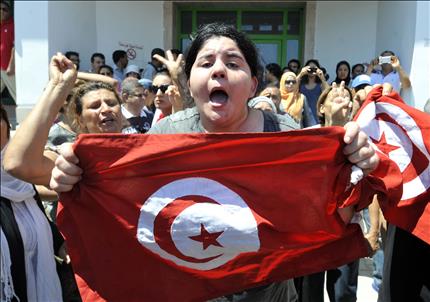 ابنة البراهمي ترفع علم تونس وسط أجواء من الغضب أمام مستشفى ولاية اريانة شمالي شرق تونس أمس (أ ف ب) 