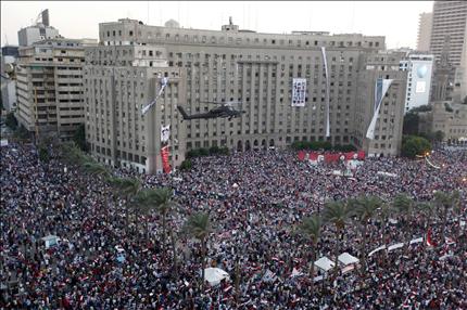 طوافة «اباتشي» فوق حشود من المتظاهرين الداعمين للجيش المصري في ميدان التحرير في القاهرة امس (رويترز) 