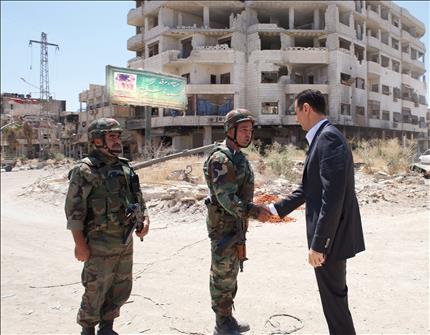 الاسد يصافح احد الجنود خلال زيارته داريا في ريف دمشق امس (ا ب ا) 