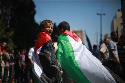 طفلان فلسطينيان يشاركان في مهرجان إحياء «يوم القدس العالمي» في مدينة غزة أمس (أ ف ب) 