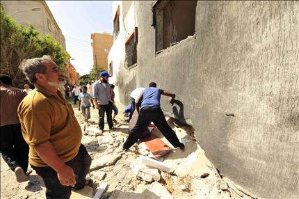 ليبيون يتفقدون موقع الانفجار في بنغازي امس (رويترز) 