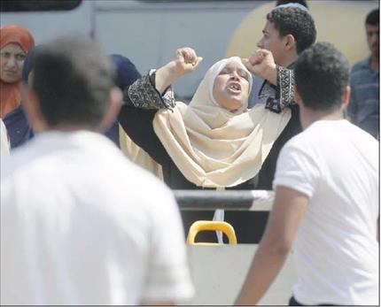 مصرية تصرخ امام مركز شرطة بولاق الدكرور في الجيزة بعد انفجار استهدفه امس (رويترز) 