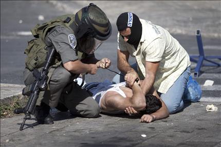 شرطيان إسرائيليان يعتقلان شاباً فلسطينياً قرب منطقة راس العمود في القدس القديمة أمس (ا ب ا) 
