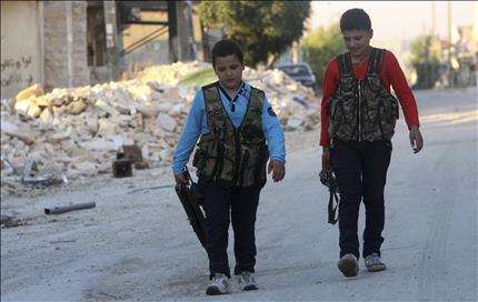 عبود (12 سنة) وشقيقه ديب (14 سنة) يحملان السلاح في صفوف المعارضة في حي الشيخ مقصود في حلب امس الاول (رويترز) 