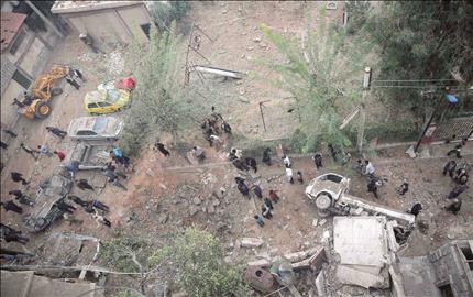 سوريون يتفقدون موقع غارة جوية في دوما في ريف دمشق امس (رويترز) 