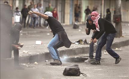 فلسطينيون يشتبكون مع قوات الاحتلال في الخليل في الضفة الغربية أمس (ا ب ا) 