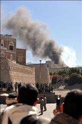 يمنيون يشاهدون أعمدة الدخان المتصاعدة من مبنى وزارة الدفاع اليمنية في صنعاء أمس (أ ب أ) 