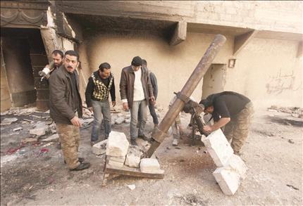 مسلحون يستعدون لإطلاق قذيفة هاون في حي بستان الباشا في حلب أمس (رويترز) 