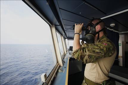 عنصر من البحرية الدنماركية يراقب بالمنظار خلال انتقال السفينة من قبرص الى قبالة مرفأ اللاذقية امس (ا ب) 