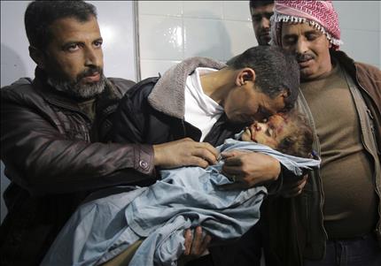 فلسطيني يحمل جثة الطفلة حلا أبو سبيخة التي قتلت في الغارة الإسرائيلية على قطاع غزة أمس (أ ب) 