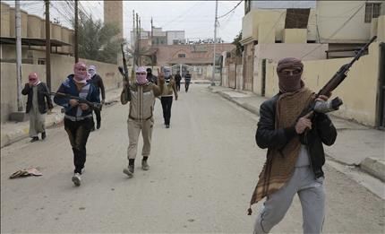 مسلحون يجولون في أحد شوارع مدينة الرمادي العراقية أمس (رويترز) 